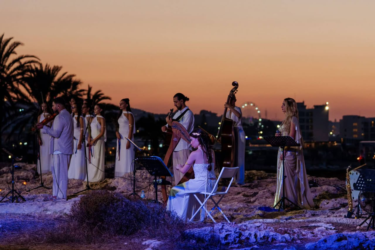 Angelina and the ensemble performing at sunset by the sea